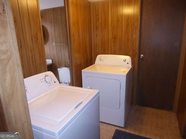 1467 Creek Rd, Hiawassee, GA 30546 - laundry area featuring washing machine and dryer, wooden walls, and light tile patterned flooring