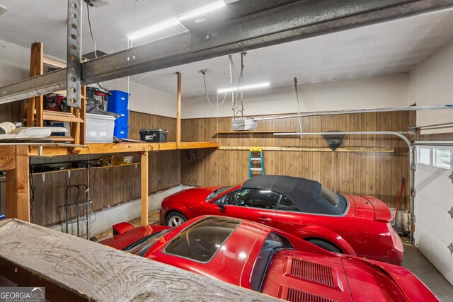 garage with a garage door opener and wood walls