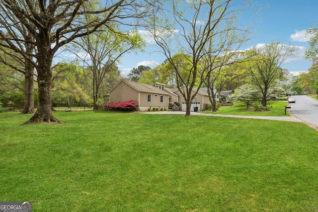 view of yard featuring an attached garage and driveway