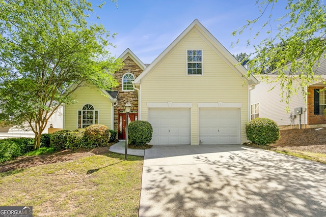 traditional-style house featuring an attached garage, a front lawn, driveway, and stone siding