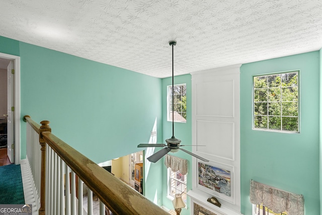 details with a ceiling fan and a textured ceiling