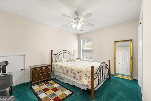 bedroom featuring a textured ceiling, visible vents, carpet flooring, and a ceiling fan