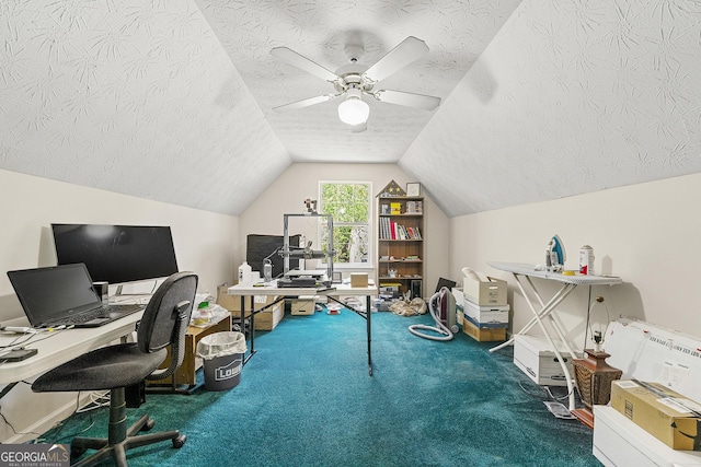 office area with vaulted ceiling, a ceiling fan, a textured ceiling, baseboards, and carpet flooring