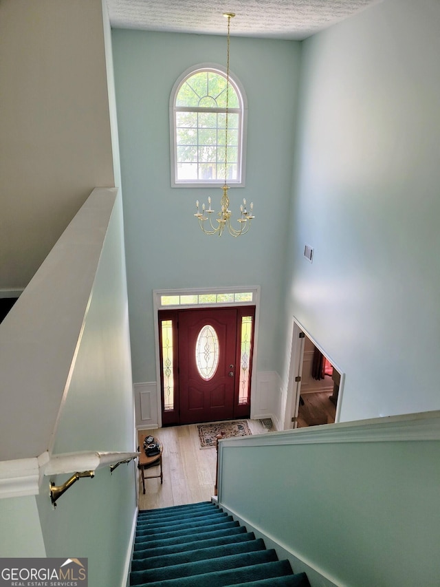 545 Goldfinch Way, Stockbridge, GA 30281 - foyer entrance featuring a high ceiling, a chandelier, wainscoting, stairway, and wood finished floors