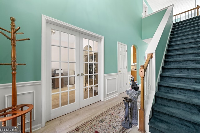 interior space with wainscoting, french doors, and wood finished floors