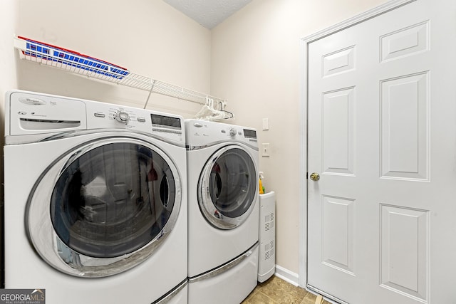 clothes washing area featuring washing machine and clothes dryer, baseboards, laundry area, and light tile patterned floors