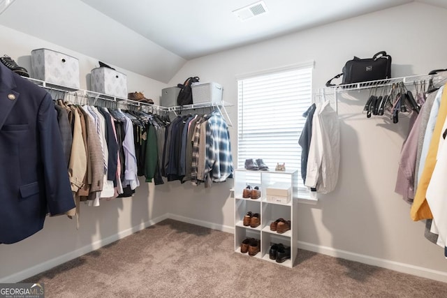 spacious closet featuring carpet flooring, vaulted ceiling, and visible vents