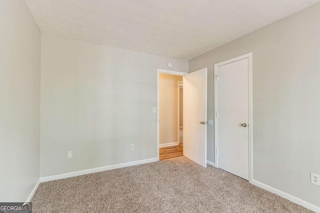 unfurnished bedroom featuring baseboards, carpet flooring, and a textured ceiling