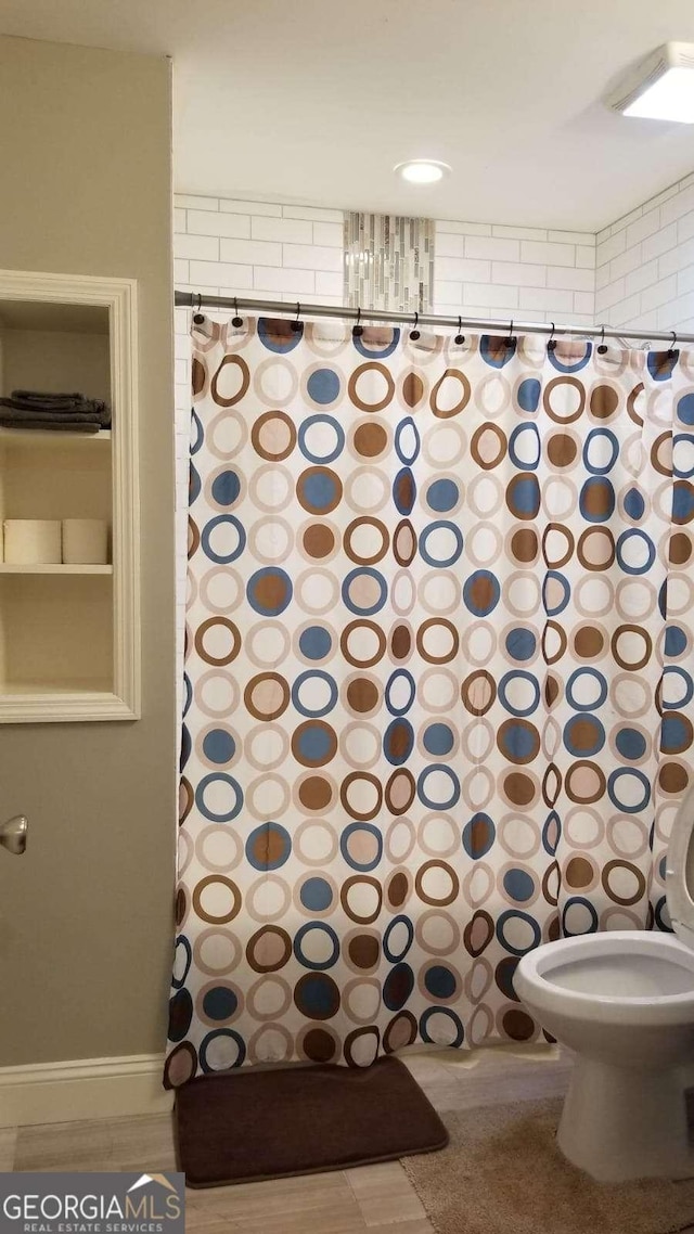 bathroom featuring a shower with shower curtain and toilet