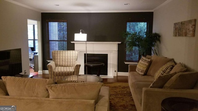 living room with wood finished floors, baseboards, ornamental molding, and a tile fireplace