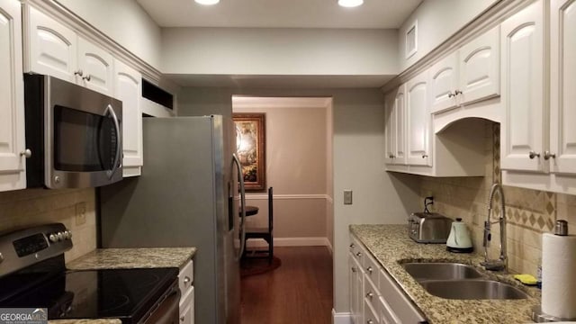 kitchen with dark wood finished floors, light stone countertops, tasteful backsplash, a sink, and stainless steel appliances