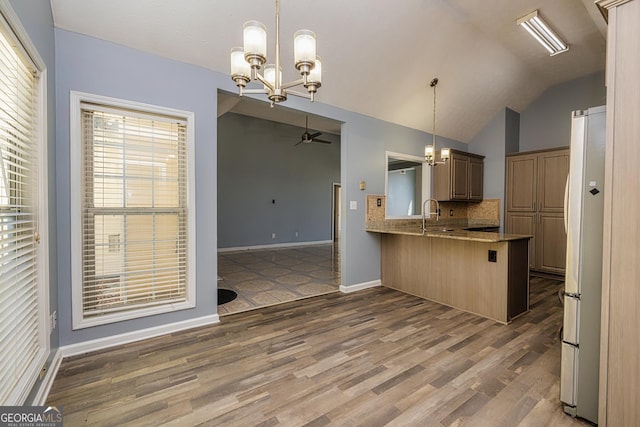 230 Hidden Brook Trl, Fayetteville, GA 30215 - kitchen with freestanding refrigerator, a chandelier, a peninsula, wood finished floors, and vaulted ceiling