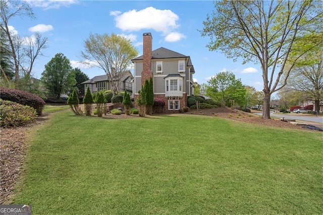 295 Sagamore Cv NW, Sugar Hill, GA 30518 - rear view of property with a yard, a chimney, and brick siding