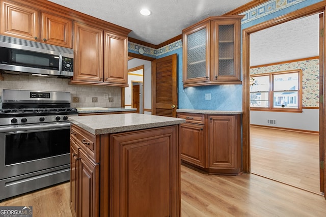 kitchen featuring stainless steel appliances, visible vents, and brown cabinetry