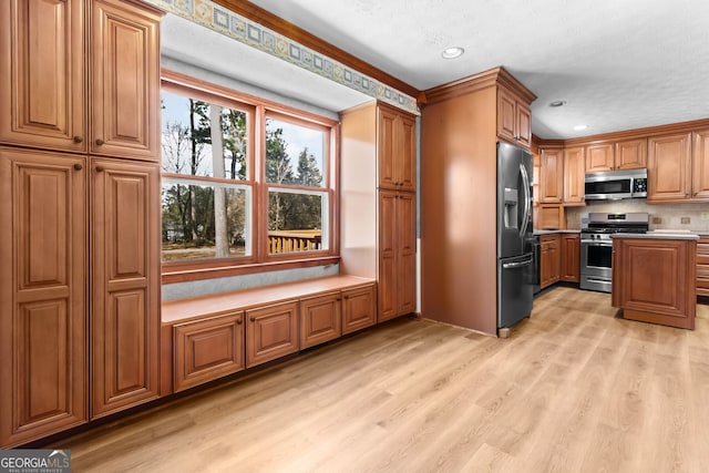 kitchen featuring light countertops, light wood-style floors, brown cabinets, recessed lighting, and stainless steel appliances