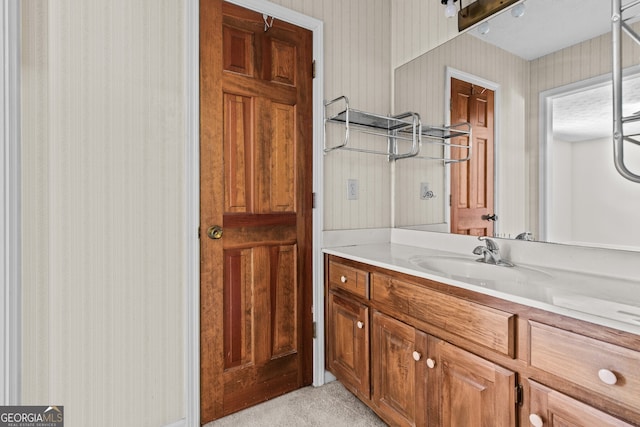 bathroom with vanity and wallpapered walls