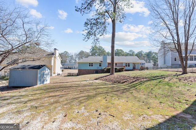 view of yard featuring a storage unit, fence, and an outdoor structure