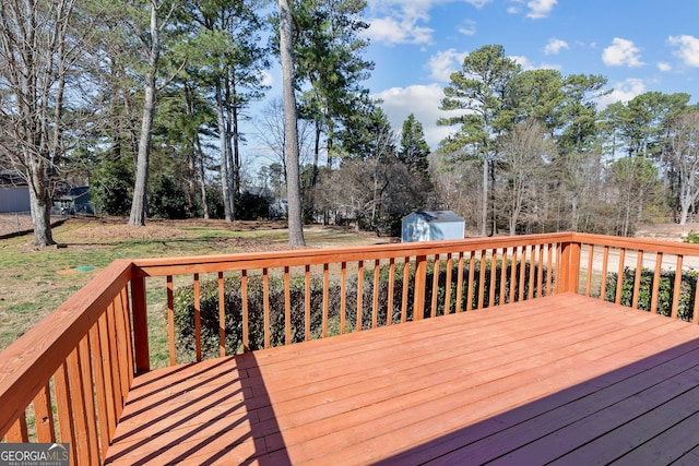 wooden deck featuring an outdoor structure, a lawn, and a shed