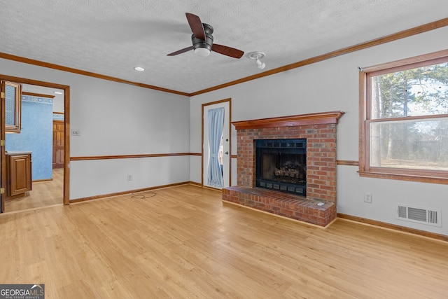 unfurnished living room with a fireplace, light wood-style flooring, a textured ceiling, a ceiling fan, and visible vents