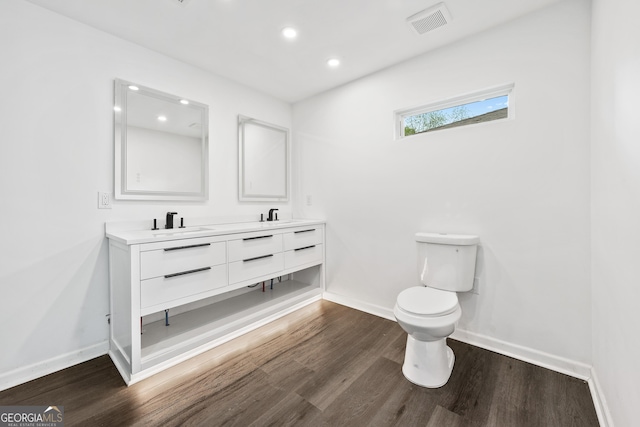 bathroom with recessed lighting, a sink, toilet, and wood finished floors