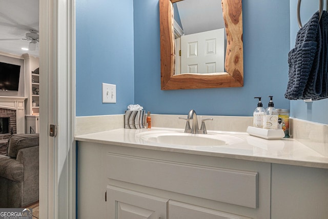bathroom with a ceiling fan, vanity, and a fireplace