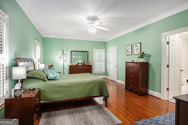 bedroom featuring crown molding, wood finished floors, and multiple windows