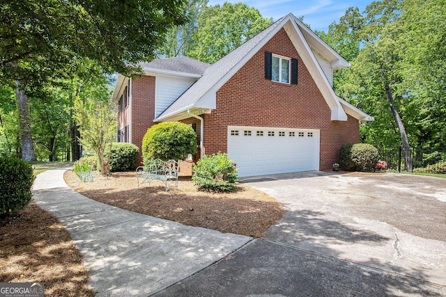 view of front of home featuring concrete driveway, fence, a garage, brick siding, and roof with shingles