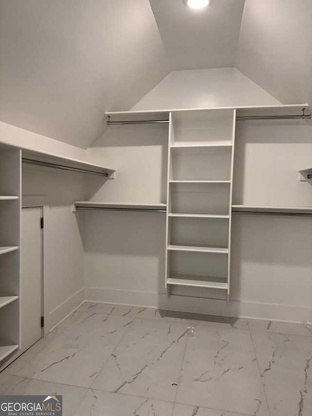 walk in closet featuring marble finish floor