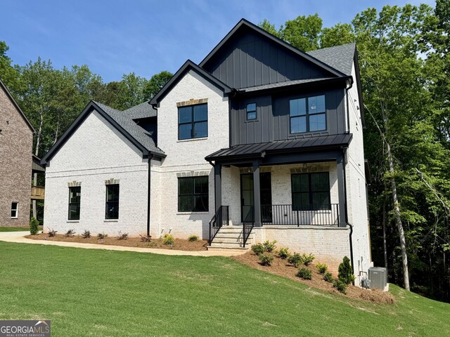 view of front of house with driveway, brick siding, a front lawn, an attached garage, and a shingled roof
