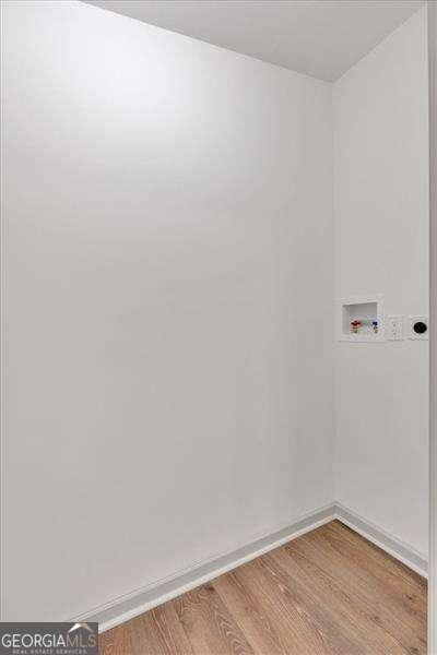 spare room with baseboards and wood finished floors