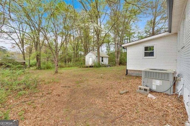view of yard with cooling unit, an outbuilding, and a storage unit