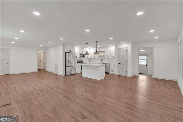 unfurnished living room with light wood-type flooring and recessed lighting