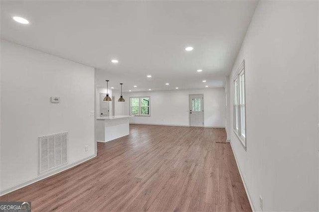 unfurnished living room with recessed lighting, light wood finished floors, and visible vents