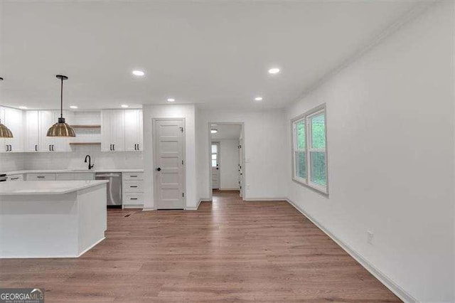 kitchen with light wood-style flooring, light countertops, open shelves, white cabinets, and dishwasher