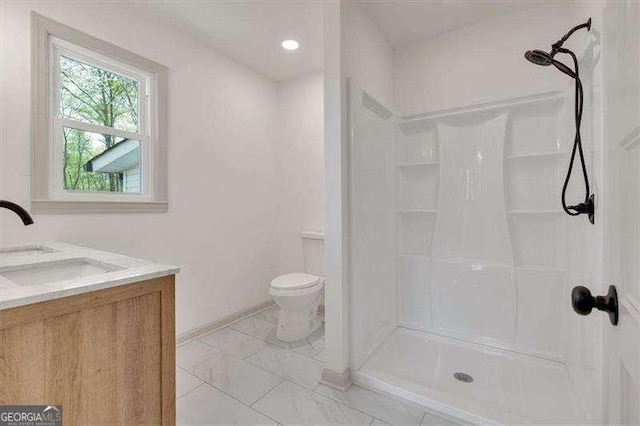 full bath featuring toilet, walk in shower, vanity, and baseboards