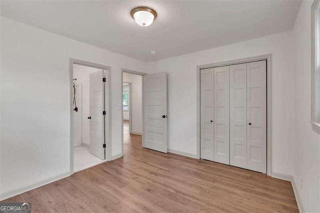 unfurnished bedroom featuring light wood-style floors, a closet, and baseboards