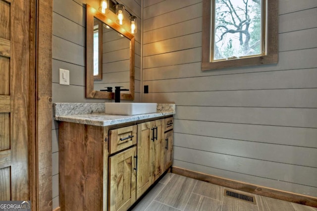 768 Cherokee Cir, Ellijay, GA 30540 - bathroom with wooden walls, visible vents, baseboards, and vanity