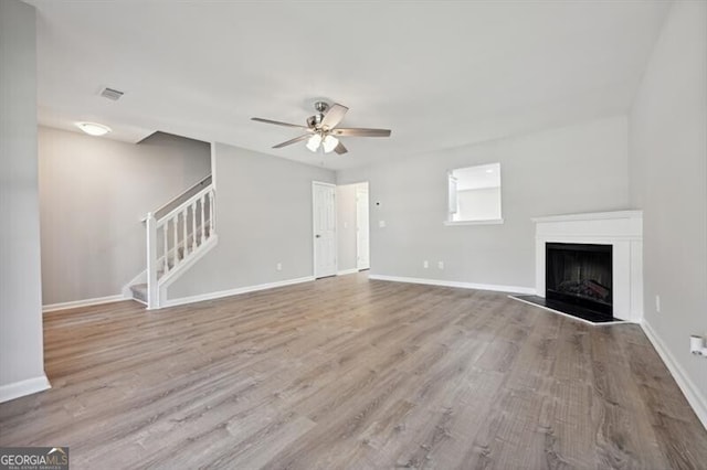 1575 April Ln, Morrow, GA 30260 - unfurnished living room with baseboards, a fireplace, a ceiling fan, stairs, and wood finished floors