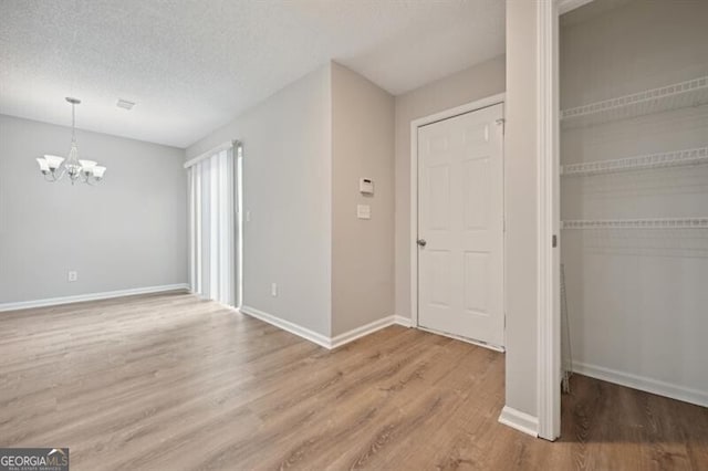 1575 April Ln, Morrow, GA 30260 - interior space featuring a textured ceiling, wood finished floors, an inviting chandelier, and baseboards