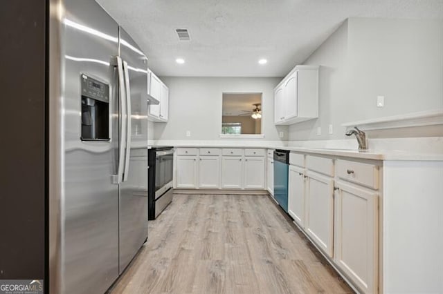 1575 April Ln, Morrow, GA 30260 - kitchen with light wood-style floors, white cabinets, visible vents, appliances with stainless steel finishes, and light countertops