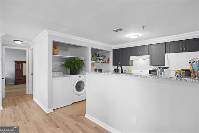 4307 Orchard Park Ct Unit A, Stone Mountain, GA 30083 - kitchen featuring under cabinet range hood, washing machine and dryer, freestanding refrigerator, crown molding, and light wood-style floors