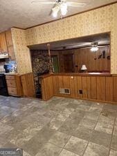 4528 Newcastle Cir, Lithonia, GA 30038 - kitchen featuring wallpapered walls, range hood, brown cabinets, light countertops, and wood walls