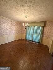4528 Newcastle Cir, Lithonia, GA 30038 - unfurnished dining area with wallpapered walls, a chandelier, wainscoting, and a textured ceiling
