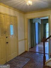 4528 Newcastle Cir, Lithonia, GA 30038 - entryway featuring brick floors, crown molding, and stairway