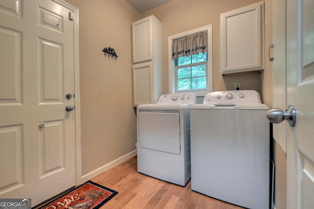 laundry room with washing machine and dryer, baseboards, light wood-style flooring, and cabinet space