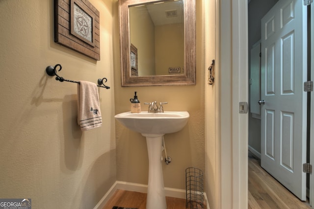 bathroom with wood finished floors, baseboards, and visible vents