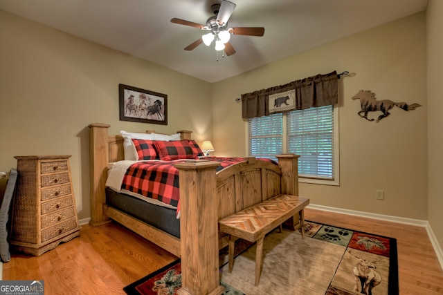 bedroom featuring baseboards, a ceiling fan, and wood finished floors