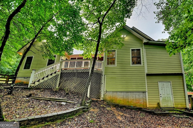 rear view of house with stairway, a deck, and crawl space