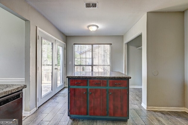 kitchen featuring light wood finished floors, visible vents, dishwasher, and red cabinets