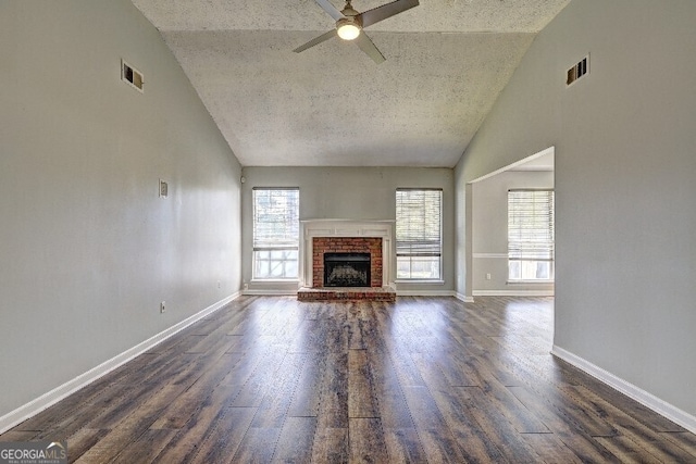 unfurnished living room with visible vents, a ceiling fan, and dark wood-style floors